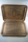 Two Indian brass rectangular trays, with engraved decoration,