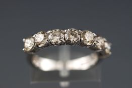 A modern white metal half hoop diamond ring.