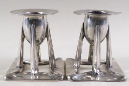 A pair of Archibald Knox style pewter candlesticks,