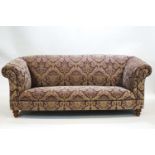 A Victorian style two seat sofa on tuned legs, in the club style,