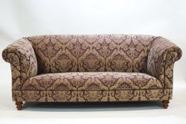 A Victorian style two seat sofa on tuned legs, in the club style,