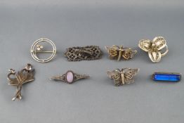 A collection of eight brooches of variable designs. Some marked for sterling silver.