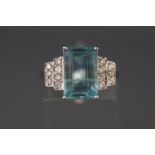 A white metal dress ring. Set with a rectangular cut aquamarine