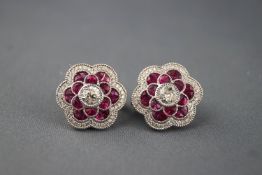 A white metal pair of flower stud earrings.