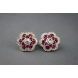 A white metal pair of flower stud earrings.