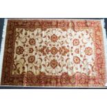 A machine woven Keshan carpet with scrolling flowers on a beige ground within one wide border,