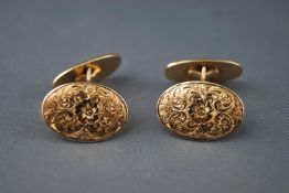 A yellow metal pair of engraved oval t-bar cufflinks. Stamped 585 for 14ct gold.