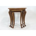 A nest of three carved hard wood tables with shaped rectangular tops