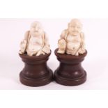 A pair of early 20th century ivory figures, of the laughing Budai, 4cm high,