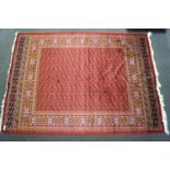 A red ground Bokhara carpet, the centre decorated with lozenge motifs in a similar border,