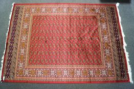 A red ground Bokhara carpet, the centre decorated with lozenge motifs in a similar border,