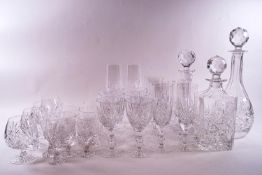 A part suite of cut glass, comprising of three decanters and stoppers, six wine glasses,