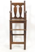 A late Georgian child's high arm chair in oak and elm, peg constructed in the traditional manner,