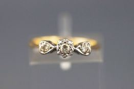 A yellow and white metal three stone diamond ring, approx 0.10cts. Stamped 18ct. Size: J 1/2,