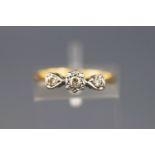 A yellow and white metal three stone diamond ring, approx 0.10cts. Stamped 18ct. Size: J 1/2,