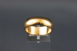 A yellow metal 7mm D shape wedding ring. Hallmarked 9ct gold, Birmingham, 1997. Size U (centre)