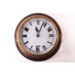 A brass cased ships timepiece on a mahogany panel with white enamel Roman dial, clock 18cm diameter,