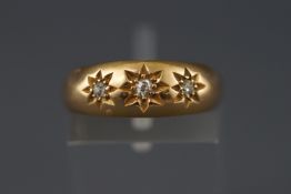 A yellow metal ring set with three old brilliant cut diamonds. Approximate total weight 0.10 carats.