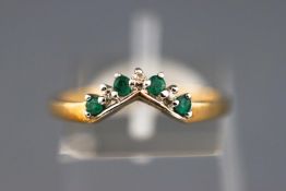 A yellow metal wishbone ring set with emerald and diamonds. Hallmarked 9ct gold, Birmingham.