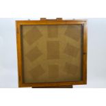 An oak framed square, shallow wall cabinet with hinged, glazed door,