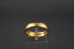 A yellow metal flat profile wedding ring. Hallmarked 18ct gold, London. Size P