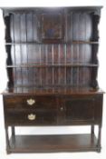 An 18th century oak dresser base with plain rectangular top over a cupboard