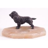 A shaped octagonal onyx ash tray set with a cast metal figure of a cocker spaniel,