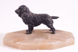 A shaped octagonal onyx ash tray set with a cast metal figure of a cocker spaniel,