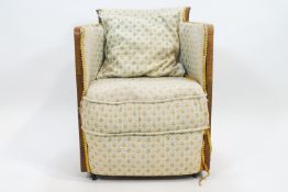 An Art deco style oak framed tub chair with brocade upholstery,