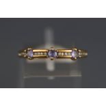 A yellow metal dress ring set with tanzanites and single cut diamonds.