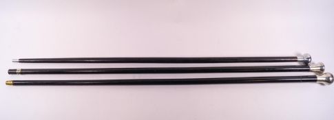 A group of three Opera canes, all in blackened hardwood and set with silver/white metal tops.
