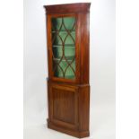 A George III mahogany corner cabinet, of traditional form, with shaped cornice,