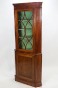 A George III mahogany corner cabinet, of traditional form, with shaped cornice,