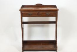 An Edwardian mahogany side table of rectangular form, the plain top with a shaped cornice,
