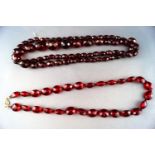 Two strands of red faceted amber beads. Gross weight: 71. grams
