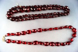 Two strands of red faceted amber beads. Gross weight: 71. grams