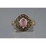 A white metal ring set with a pale amethyst and finished with marcasites. Stamped 925 for silver.