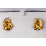 A yellow gold pair of Carrera Y Carrera earrings stylized as a cherub with a moon,