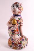 A ceramic figure of a crouching monkey decorated in the Imari palette,