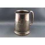 A silver mug with a thick glass bottom, with plain tubular 'C' form handle,