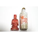A Chinese porcelain snuff bottle decorated with figures in a landscape in rust and a red stained