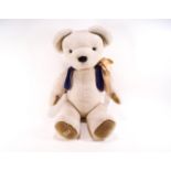 A Merrythought teddy bear wearing a blue waistcoat, stitched labels,