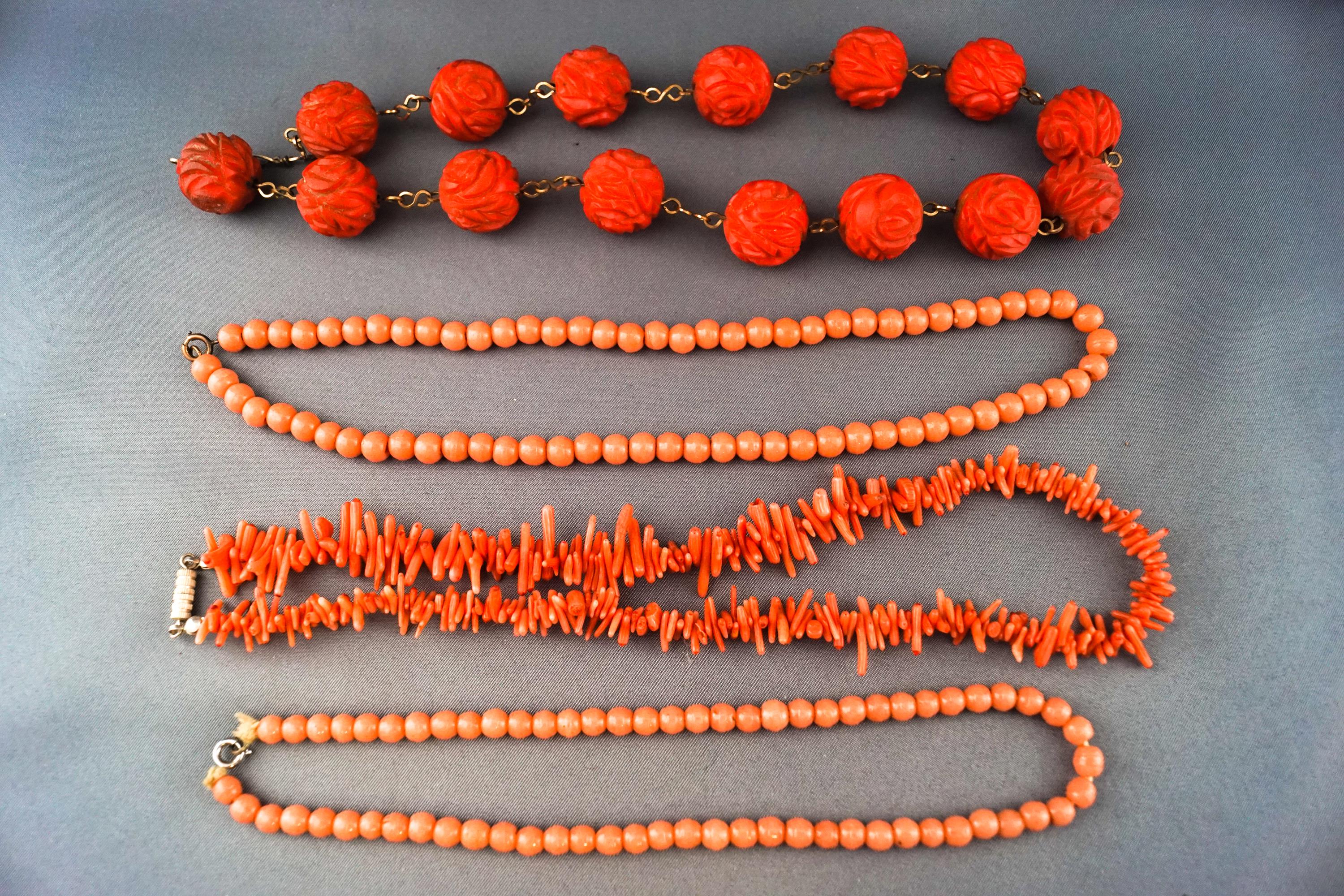 A collection of coral necklaces to include a large carved beaded necklace,