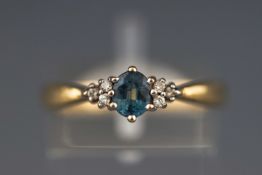 A yellow metal dress ring set with an oval sapphire and six diamonds