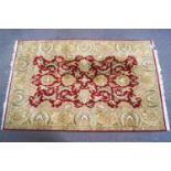 A large knotted wool Asian style carpet with a central claret field