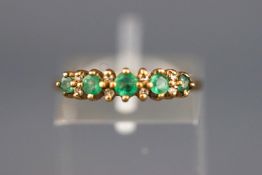 A yellow metal half hoop ring set with emerald and diamond. Hallmarked 9ct gold, Birmingham.
