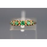 A yellow metal half hoop ring set with emerald and diamond. Hallmarked 9ct gold, Birmingham.