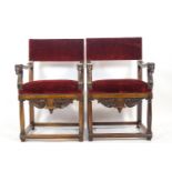 A pair of Spanish style arm chairs in carved hard wood with over stuffed rectangular back pads,