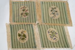 Four gros point needlework chair seat covers with floral medallions on a ground of green stripes,