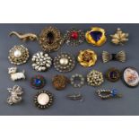 A collection of twenty one costume brooches of various designs, all finished in base metal.